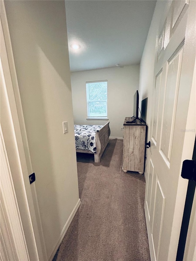 bedroom featuring dark colored carpet and baseboards