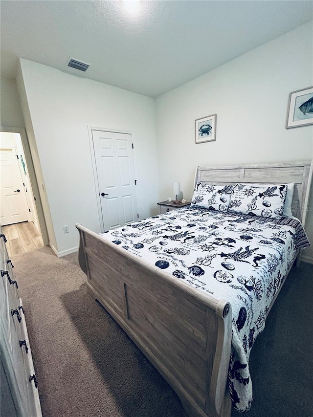 bedroom featuring light carpet, visible vents, and baseboards