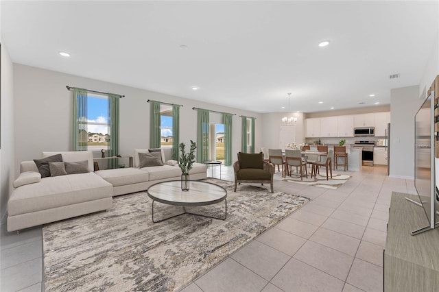 living area with light tile patterned flooring, visible vents, recessed lighting, and an inviting chandelier