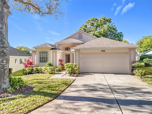 view of front of home with stucco siding, an attached garage, a shingled roof, and driveway