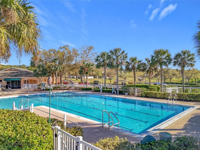 community pool featuring a patio and fence