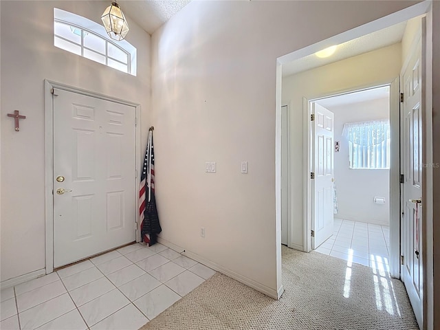 foyer entrance with light tile patterned floors and baseboards