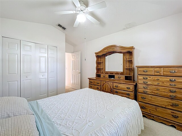 bedroom featuring visible vents, a closet, carpet flooring, ceiling fan, and vaulted ceiling