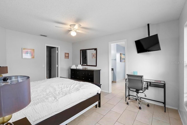 bedroom with visible vents, baseboards, ceiling fan, light tile patterned floors, and a textured ceiling