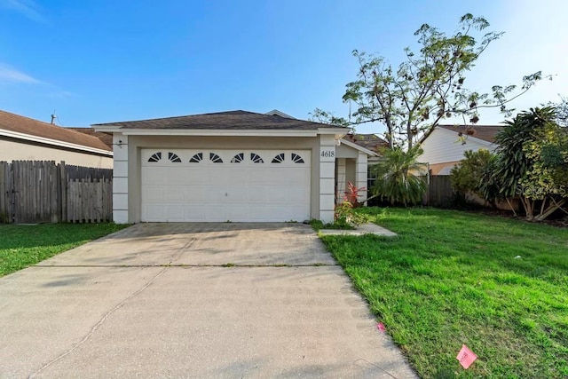 view of front facade with a front lawn, fence, driveway, and stucco siding