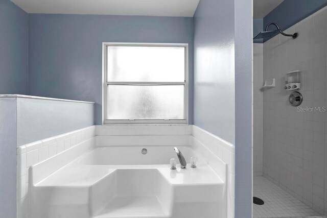 bathroom featuring a garden tub and a tile shower