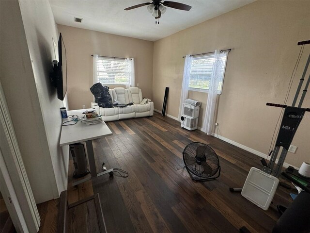 office with visible vents, heating unit, hardwood / wood-style floors, baseboards, and ceiling fan