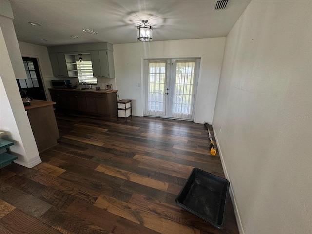 interior space with visible vents, stainless steel microwave, baseboards, french doors, and dark wood-style floors