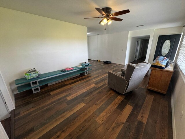 living room featuring dark wood-type flooring and ceiling fan