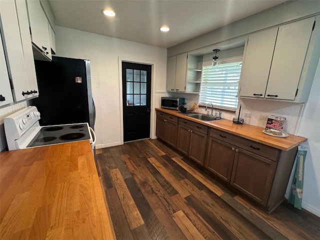 kitchen featuring butcher block countertops, a sink, open shelves, dark wood-style floors, and stainless steel appliances