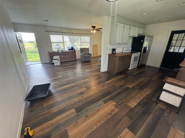 kitchen featuring wooden counters, dark wood-type flooring, white range with electric cooktop, open floor plan, and stainless steel fridge