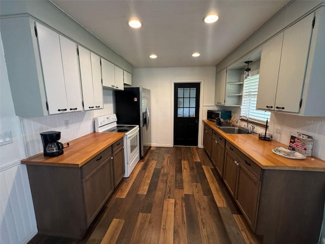 kitchen with stainless steel microwave, wooden counters, dark wood finished floors, electric stove, and a sink