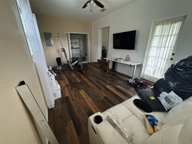 living room with dark wood finished floors, electric panel, visible vents, and ceiling fan