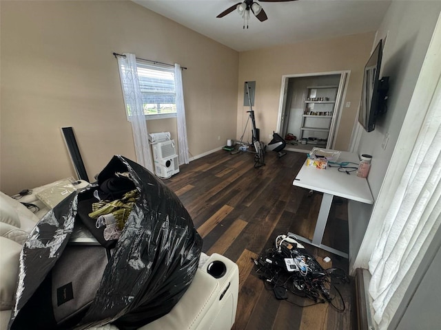 workout area featuring dark wood-style floors, baseboards, and a ceiling fan