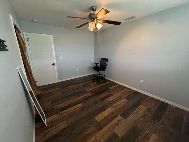 empty room featuring visible vents, baseboards, dark wood-style floors, and a ceiling fan