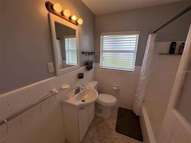 full bathroom with tile patterned flooring, toilet, vanity, and tile walls