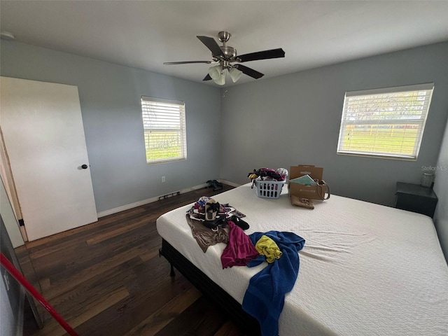 bedroom featuring dark wood-type flooring, a ceiling fan, and baseboards