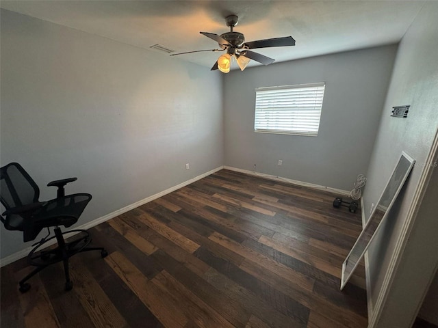 unfurnished office featuring dark wood finished floors, visible vents, ceiling fan, and baseboards