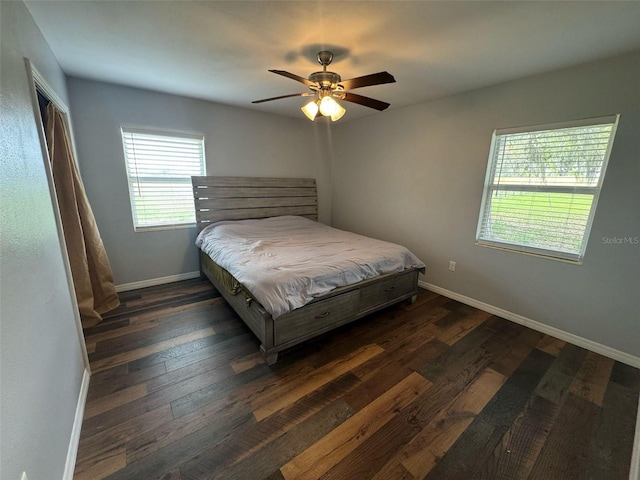 bedroom featuring a ceiling fan, baseboards, and dark wood-style flooring