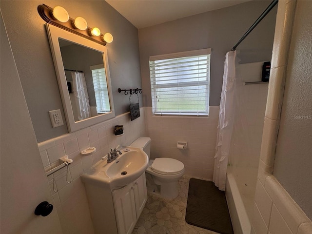 full bathroom with vanity, wainscoting, tile walls, toilet, and tile patterned floors