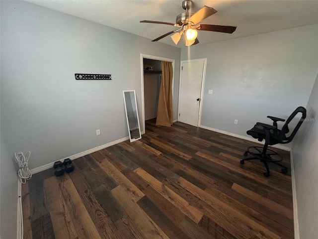 unfurnished office with baseboards, dark wood-type flooring, and ceiling fan