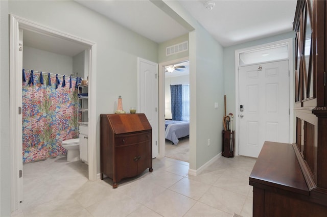 foyer entrance with light tile patterned floors, visible vents, baseboards, and a ceiling fan