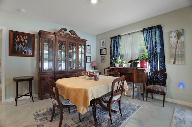 dining room featuring baseboards and light tile patterned flooring