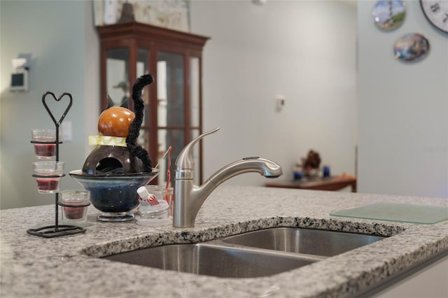 kitchen with light stone counters and a sink