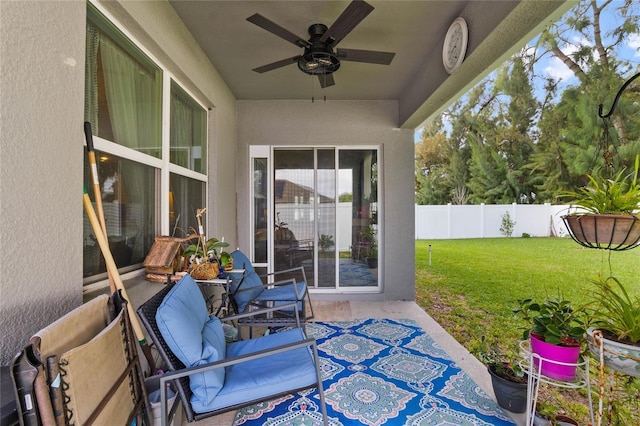 view of patio / terrace with ceiling fan and fence