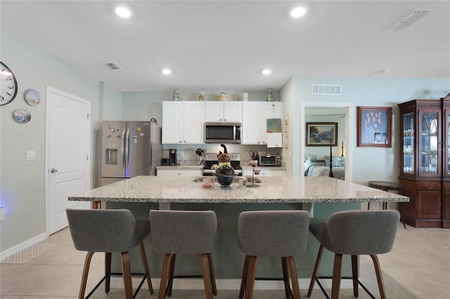 kitchen with a breakfast bar area, visible vents, and appliances with stainless steel finishes