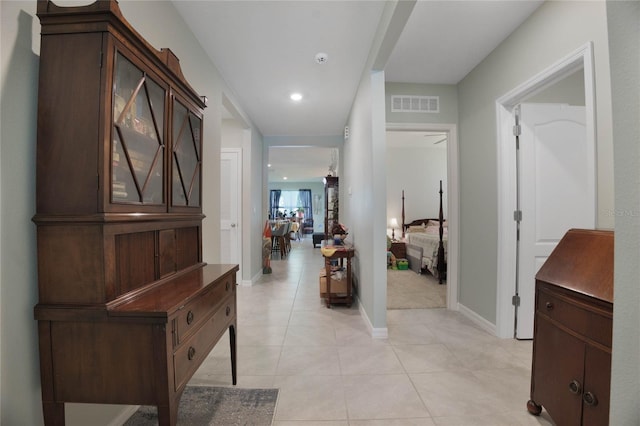 corridor featuring light tile patterned floors, visible vents, recessed lighting, and baseboards