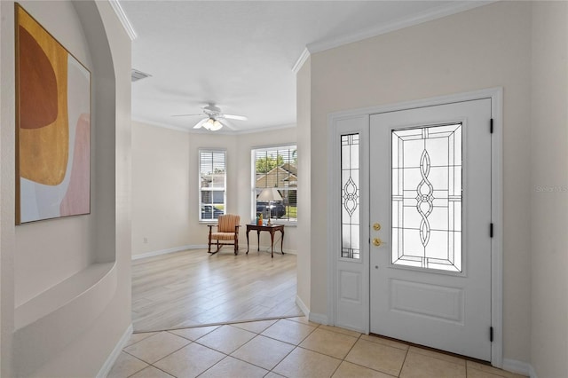 foyer with light tile patterned floors, visible vents, ceiling fan, and crown molding