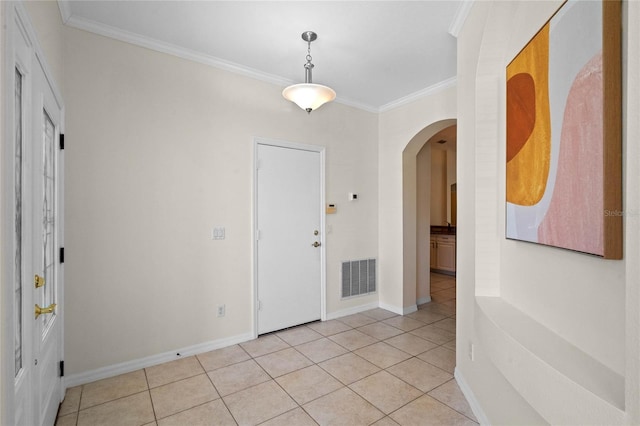 entrance foyer with arched walkways, visible vents, light tile patterned floors, and ornamental molding