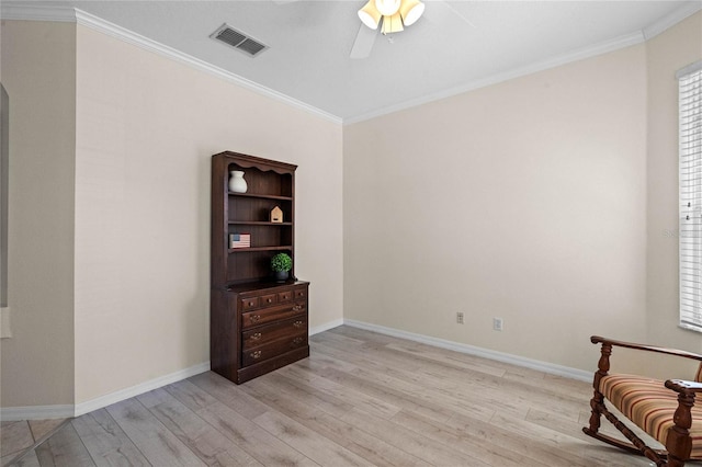 living area with light wood finished floors, visible vents, baseboards, ornamental molding, and a ceiling fan