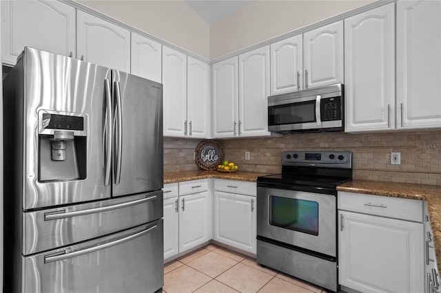 kitchen with light tile patterned flooring, decorative backsplash, white cabinets, and stainless steel appliances