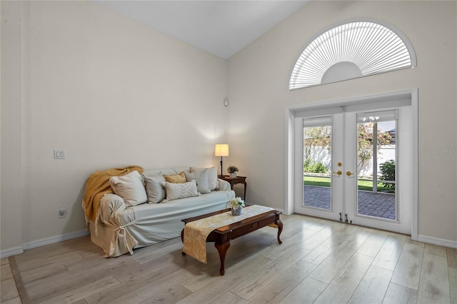 sitting room with french doors, light wood-type flooring, and baseboards