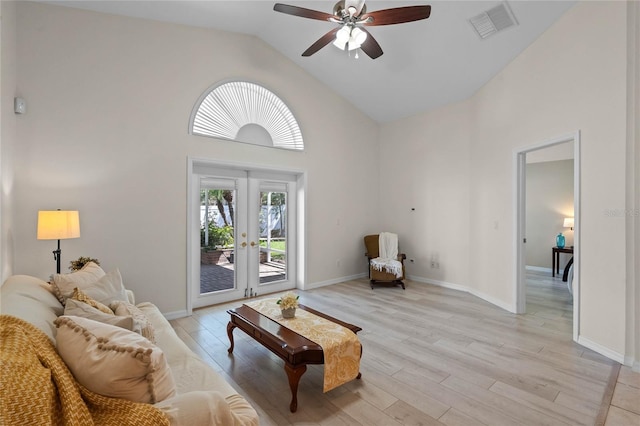 living area featuring visible vents, high vaulted ceiling, french doors, light wood-style floors, and baseboards