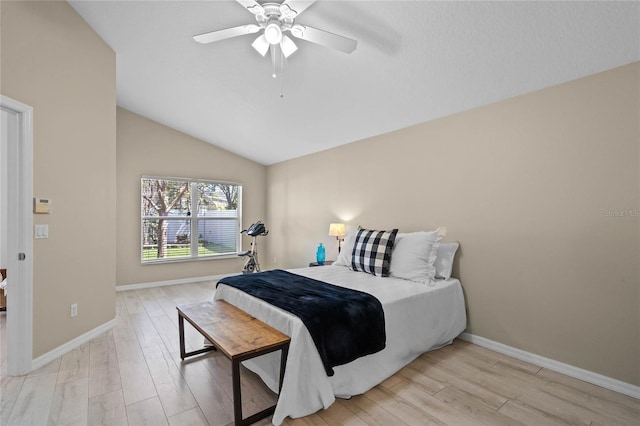 bedroom featuring baseboards, a ceiling fan, light wood-style floors, and vaulted ceiling