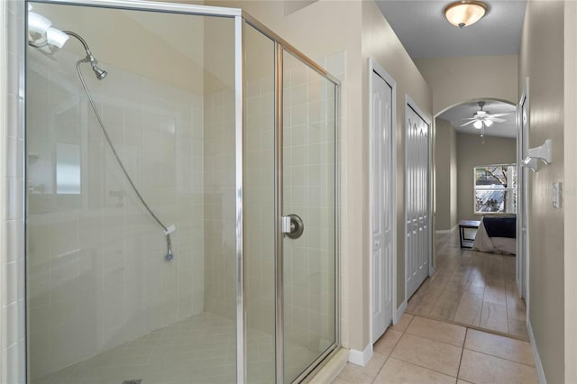 full bath featuring tile patterned floors, baseboards, and a stall shower