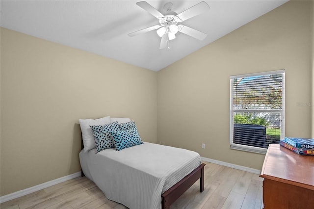 bedroom with light wood-type flooring, baseboards, a ceiling fan, and vaulted ceiling