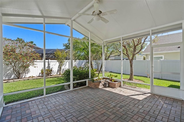 unfurnished sunroom featuring vaulted ceiling with beams and ceiling fan