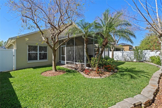 view of yard featuring a gate, fence, and a sunroom