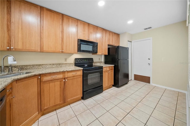 kitchen featuring visible vents, black appliances, a sink, recessed lighting, and light stone countertops