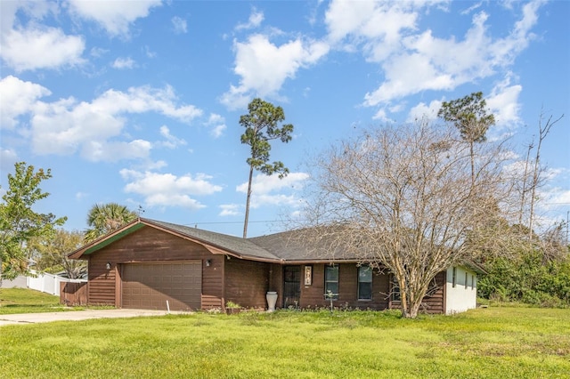 ranch-style home featuring a front lawn, a garage, and driveway