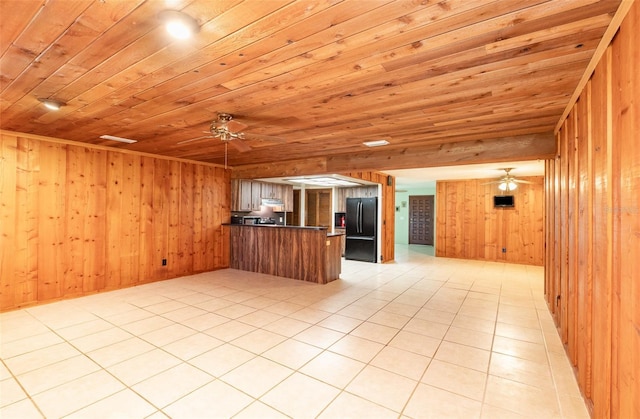 kitchen featuring a peninsula, open floor plan, wooden ceiling, and freestanding refrigerator