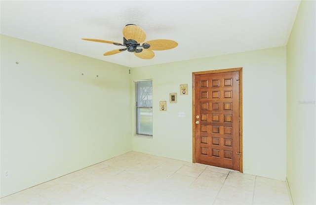 spare room with baseboards and ceiling fan