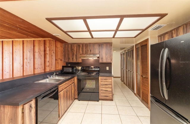 kitchen featuring dark countertops, visible vents, under cabinet range hood, black appliances, and a sink