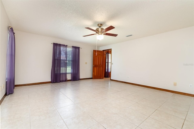 empty room featuring visible vents, a textured ceiling, light tile patterned floors, baseboards, and ceiling fan