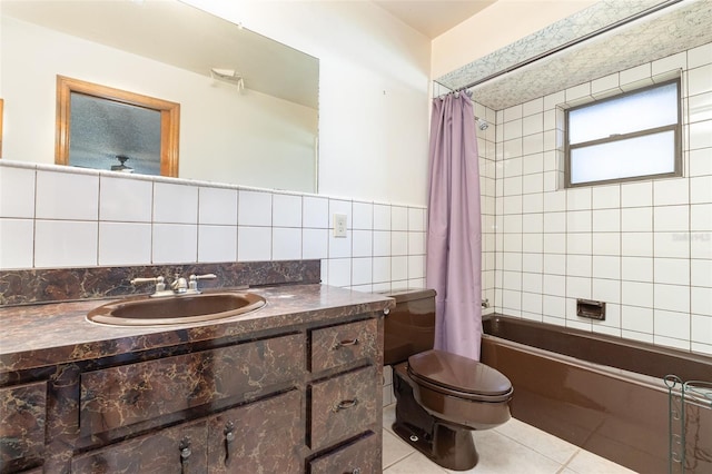 full bath featuring vanity, shower / bath combo with shower curtain, tile walls, toilet, and tile patterned floors