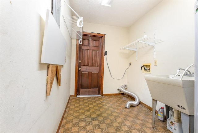 laundry room with hookup for a washing machine, baseboards, laundry area, a textured ceiling, and tile patterned floors